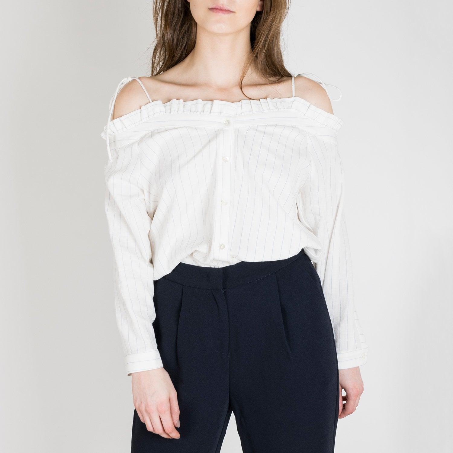 Slim-fitting, shoulder-tie tank top with thin black vertical stripes.