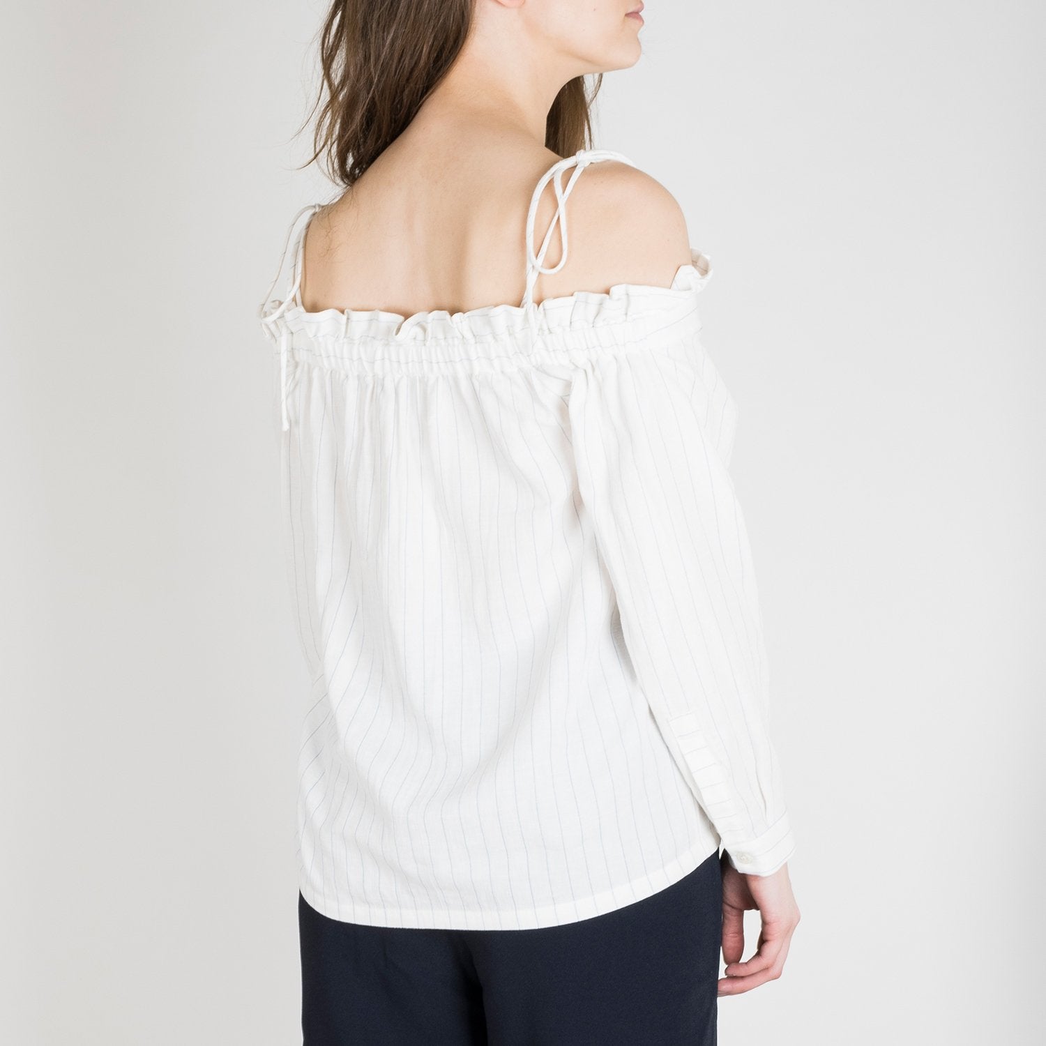 Slim-fitting, shoulder-tie tank top with thin black vertical stripes.