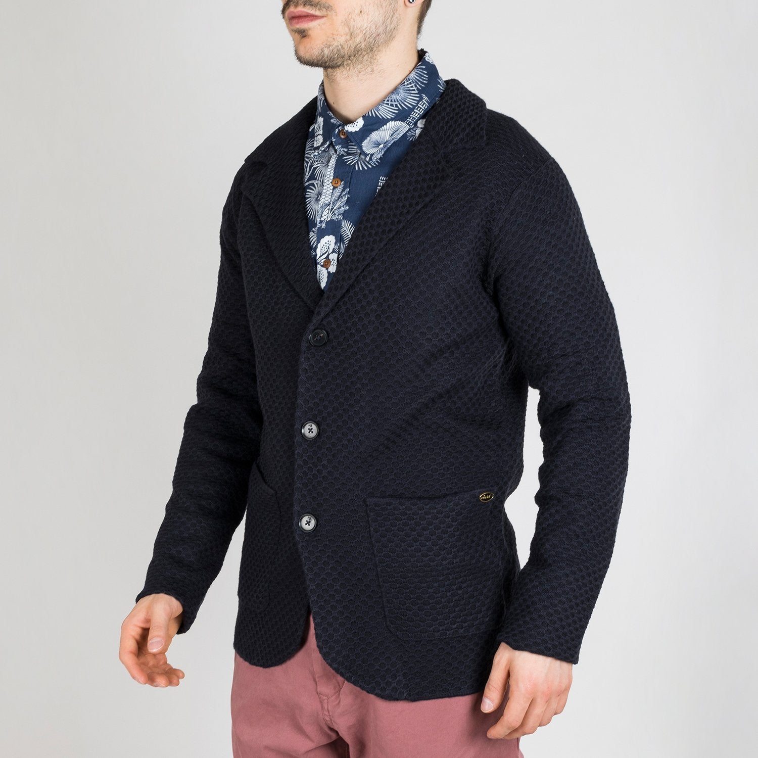 Dark colored cardigan featuring a structured wool blend knit and notch lapels.