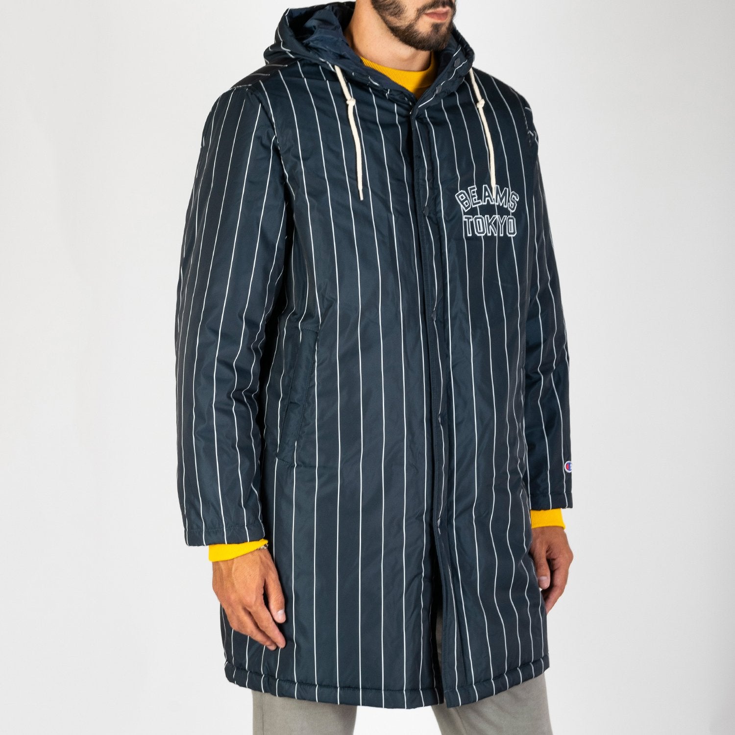 Champion x Beams thermal padded baseball coat made from a dark navy padded durable polyester with white stripes.