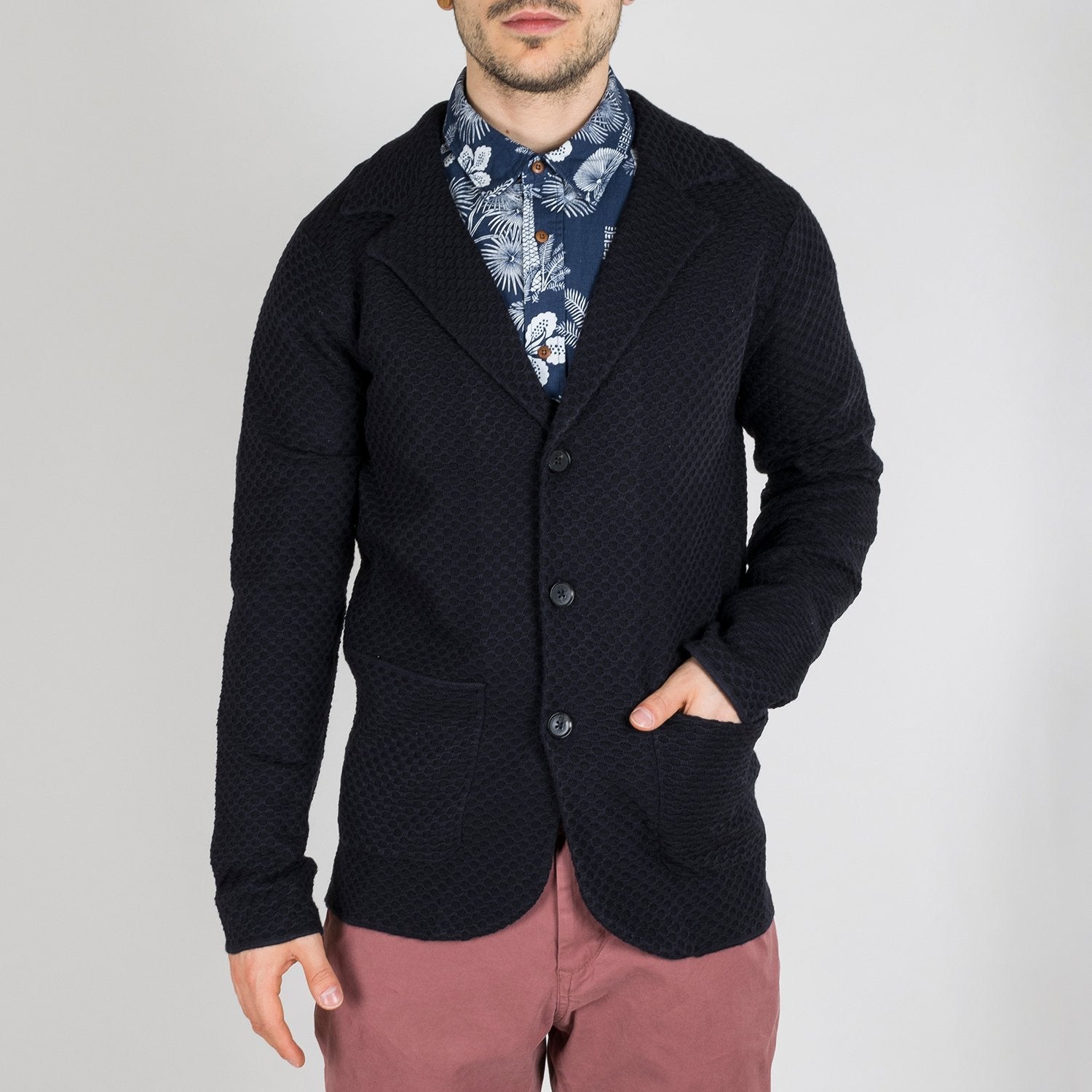 Dark colored cardigan featuring a structured wool blend knit and notch lapels.
